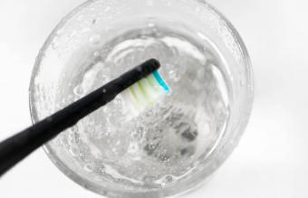 Toothbrush being disinfected in hydrogen peroxide and water